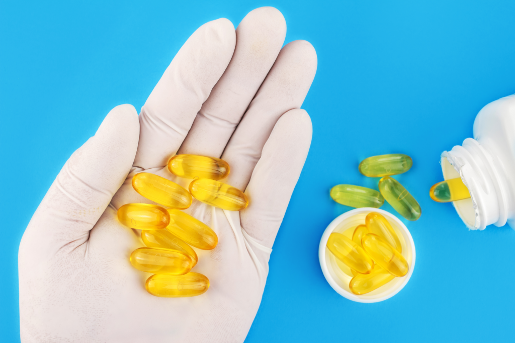person holding yellow tablets of Omega 3